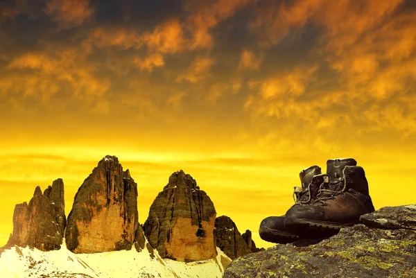 Gün batımında Tre Cime di Lavaredo arka planda kayada Hiking ayakkabıları — Stok fotoğraf