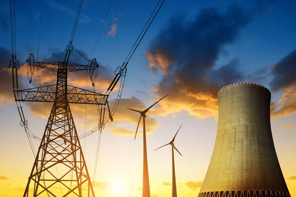 Central nuclear con aerogeneradores y pilón eléctrico al atardecer . — Foto de Stock