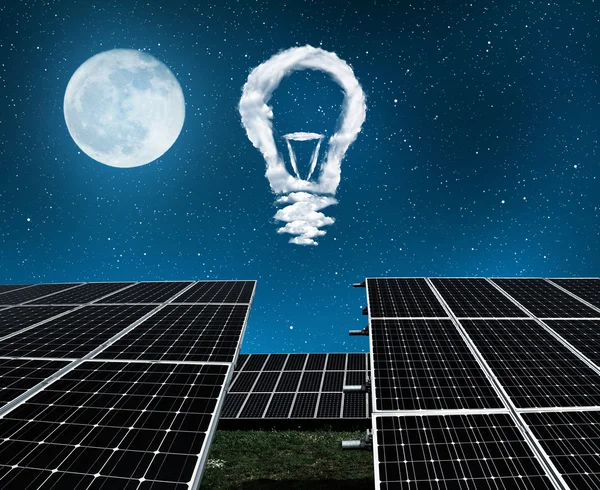 Solar panels with lightbulbs from clouds in night . — Stock Photo, Image