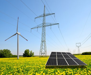 Güneş paneli ile rüzgar türbini ve elektrik direkleri.