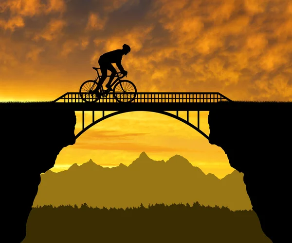 Велосипедист едет по мосту — стоковое фото