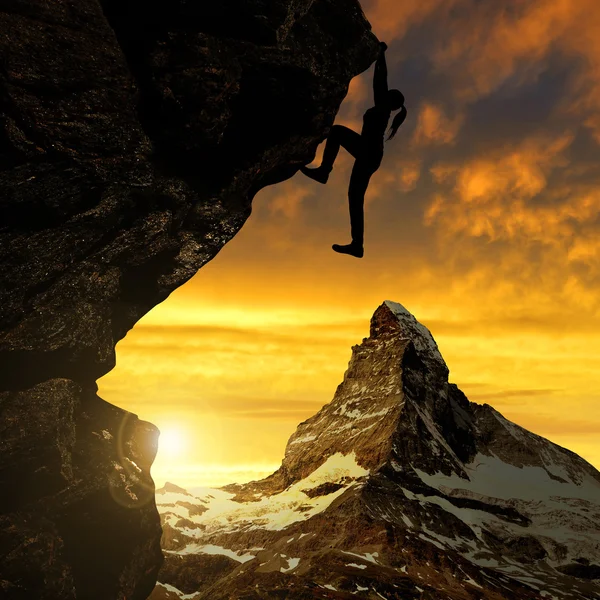 Silhoutte of girl climbing on rock at sunset — Stock Photo, Image