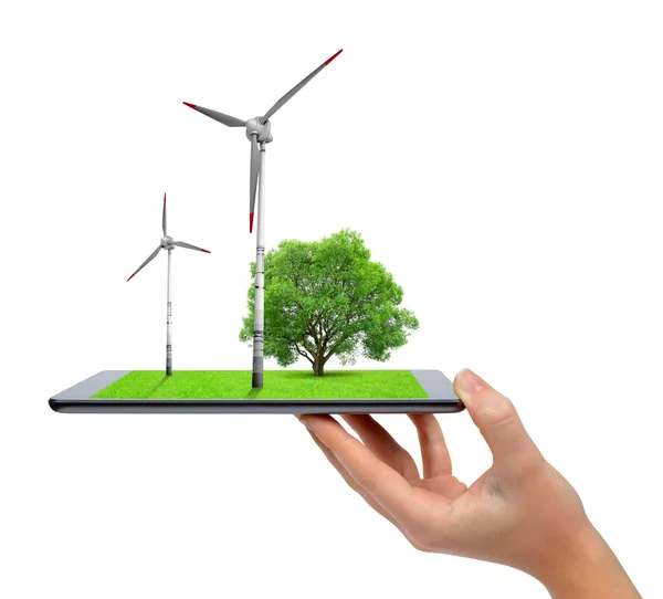 Ruka držící digitální tablet se větrnými turbínami a stromy . — Stock fotografie
