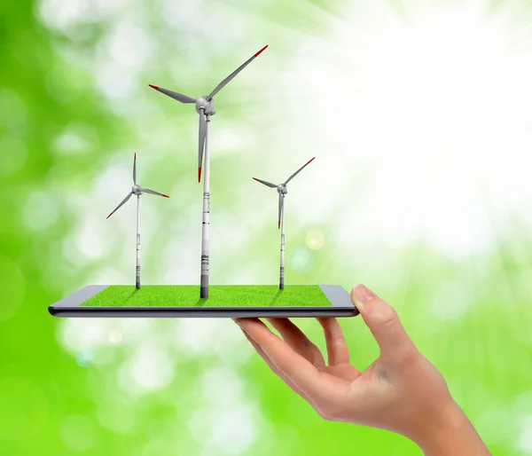 Hand holding digital tablet with a wind turbines — Stock Photo, Image
