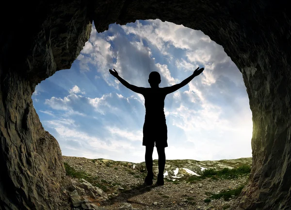 Girl standing in front of the entrance to the cave — Stock Photo, Image