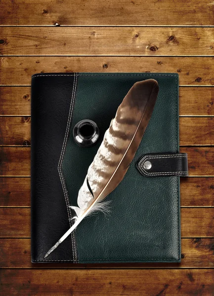 Leather notebook and feather with ink bottle. — Stock Photo, Image