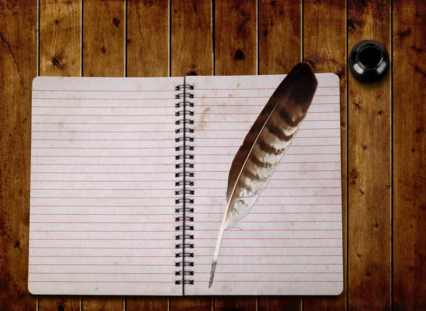 Caderno aberto e pena com garrafa de tinta — Fotografia de Stock