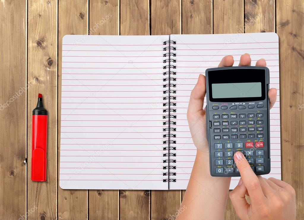 Hands with calculator in the background notebook