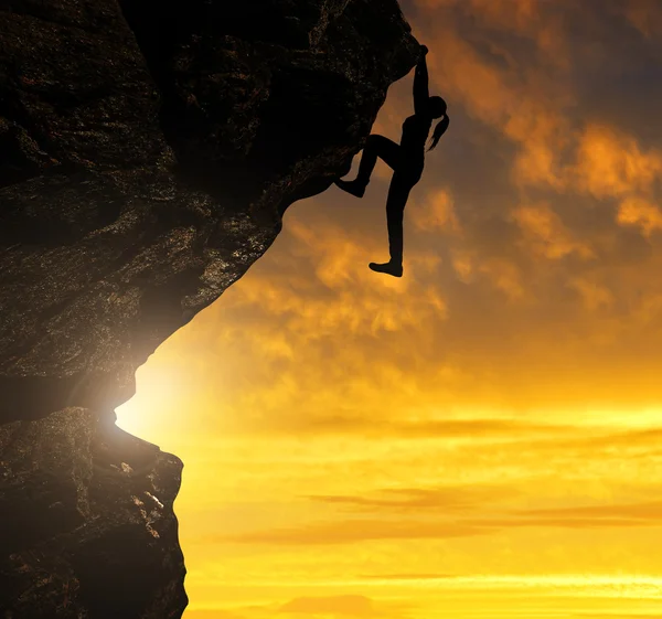 Silhoutte of girl climbing on rock — Stock Photo, Image
