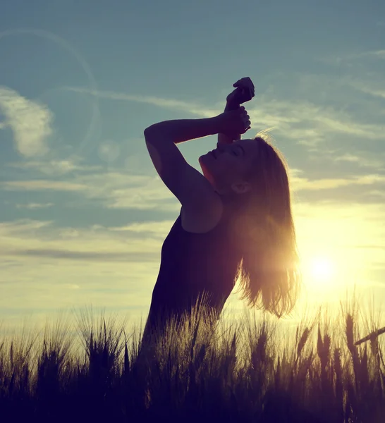Silhouette of a girl in a barley field — Stock Photo, Image