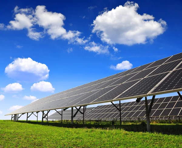 Paneles solares contra cielo azul con nubes . — Foto de Stock