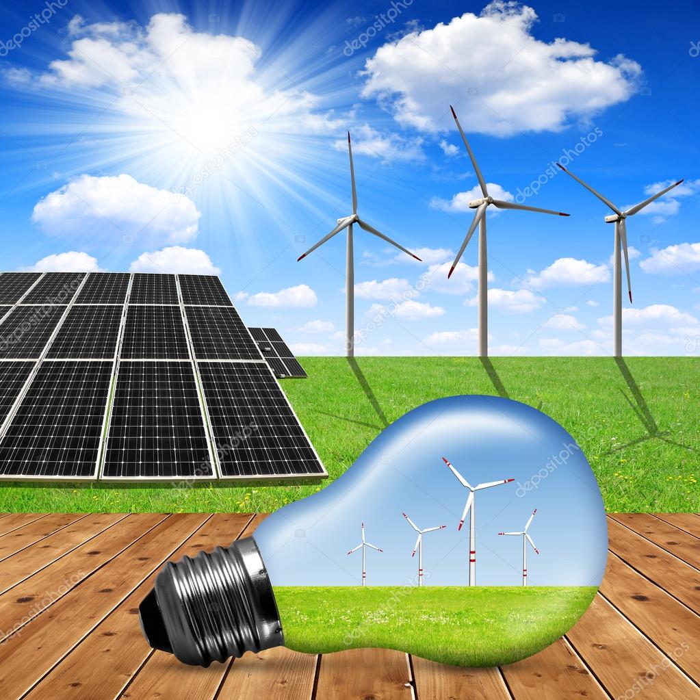 Eco light bulb in the background solar panels and wind turbines Stock