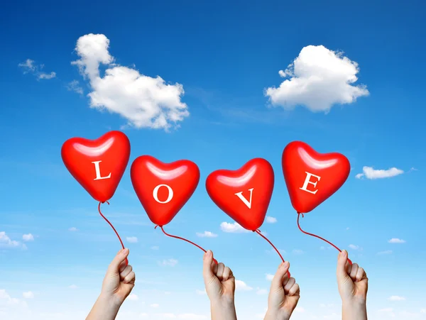 Hand holding a red heart balloons. — Stock Photo, Image