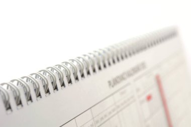 Beyaz arkaplanda bir spiral takvimin kapatılması.