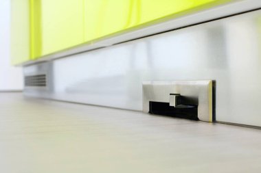 Mutfaktaki etek tahtasına yerleştirilmiş merkezi elektrikli süpürge tekme süpürücü..