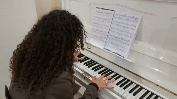 Young lady plays on piano — Stock Video