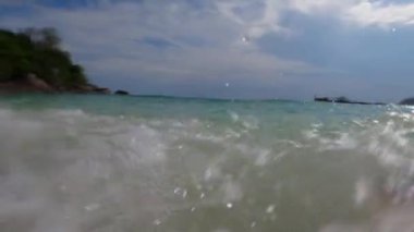 Dalgalar sahilde tekrar tekrar ayaklara vurur.