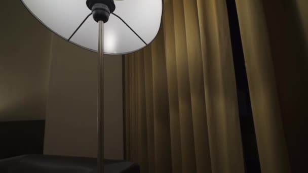夜は茶色のカーテンと黒いソファ付きのベッドルームランプ — ストック動画