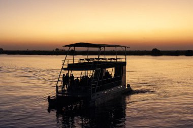 Chobe Nehri 'nde Namibya ve Botswana arasında geçen bir nehir teknesini tasvir eden açık hava sahnesi.