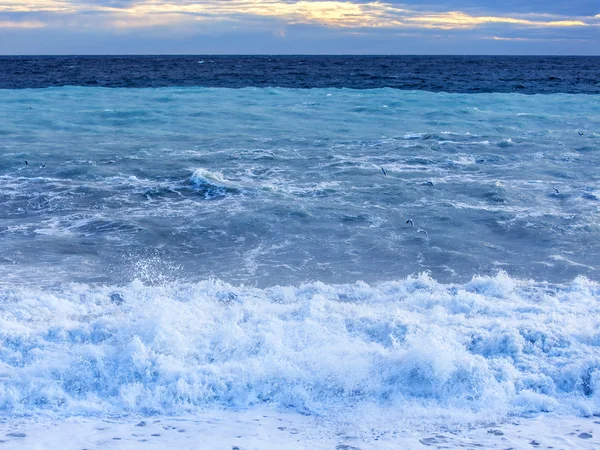海の風景です。サーフィンと嵐の波のライン点灯日没の太陽の梁. — ストック写真