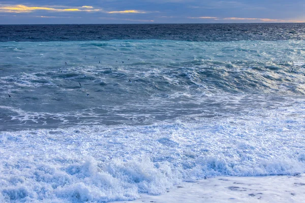 Θαλασσινό τοπίο. Τη γραμμή από μια κύματα surf και θύελλα ανάβει με τις ακτίνες του ήλιου ηλιοβασίλεμα. — Φωτογραφία Αρχείου