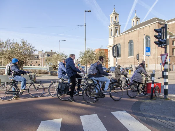 AMSTERDAM, NETHERLANDS on April 1, 2016. Вид на город. Велогонщики остановились на светофоре — стоковое фото