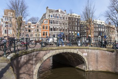Amsterdam, Hollanda 1 Nisan 2016 üzerinde. Bahar sabahı tipik kent görünümünde. Kanal ve Binalar bentleri tarihinde XVII-XVIII inşaatın Köprüsü