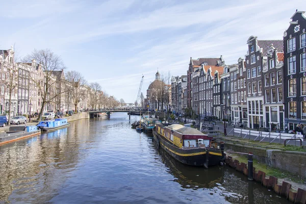 AMSTERDAM, NETHERLANDS on April 1, 2016. Типичный вид на город весной утром. Канал и здания XVII-XVIII строительства на набережных — стоковое фото