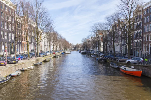 AMSTERDAM, PAÍSES BAJOS 1 DE ABRIL DE 2016. Típica vista urbana en la mañana de primavera. El canal y los edificios de la construcción XVII-XVIII sobre terraplenes — Foto de Stock