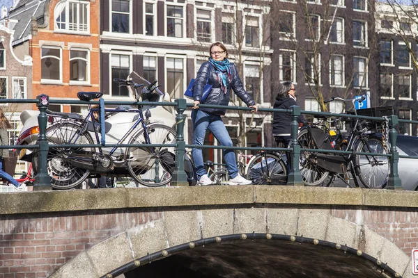 Amsterdam, Niederlande am 1. April 2016. Typische Stadtansicht am Frühlingsmorgen. die Brücke durch den Kanal und die Gebäude der xvii-xviii-Konstruktion auf den Dämmen — Stockfoto