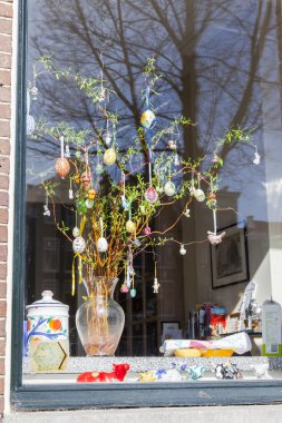 Amsterdam, Hollanda 1 Nisan 2016. Bahar sabahı tipik şehir manzarası. Eski binalar Paskalya tarafından dekore büyük pencereyansıtılır