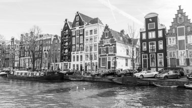 AMSTERDAM, NETHERLANDS on APRIL 1, 2016. Typical urban view in the spring morning. The channel and buildings of the XVII-XVIII construction on embankments clipart