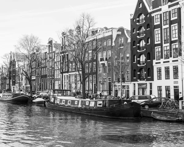 AMSTERDAM, PAÍSES BAJOS 1 DE ABRIL DE 2016. Típica vista urbana en la mañana de primavera. El canal y los edificios de la construcción XVII-XVIII sobre terraplenes — Foto de Stock