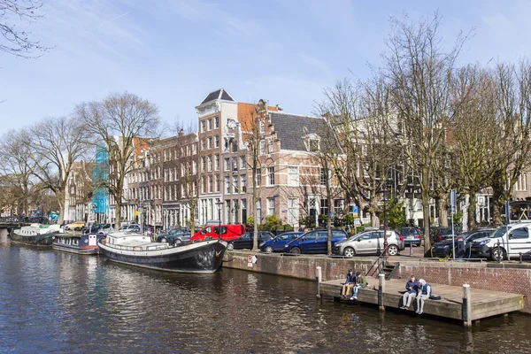 AMSTERDAM, NETHERLANDS on April 1, 2016. Типичный вид на город весной утром. Канал и здания XVII-XVIII строительства на набережных — стоковое фото