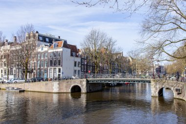 Amsterdam, Hollanda 1 Nisan 2016 üzerinde. Bahar sabahı tipik kent görünümünde. Kanal ve Binalar bentleri tarihinde XVII-XVIII inşaatın Köprüsü