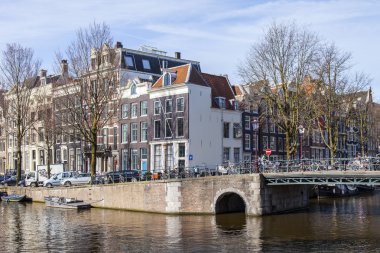 Amsterdam, Hollanda 1 Nisan 2016 üzerinde. Bahar sabahı tipik kent görünümünde. Kanal ve Binalar bentleri tarihinde XVII-XVIII inşaatın Köprüsü
