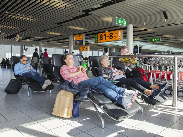 Amsterdam, Hollanda 1 Nisan 2016. İnsanlar Amsterdam havaalanı Schiphol bir bekleme odasında yatılı bekliyoruz — Stok fotoğraf