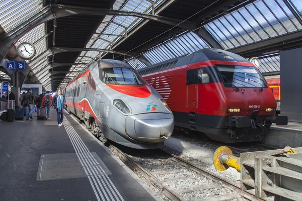 Schweiz på den 26 mars, 2016. Järnvägsstationen. Den moderna tåg på plattformen. Passagerarna går på plattformen. — Stockfoto