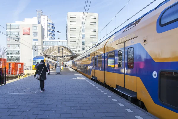 AMSTERDAM, PAÍSES BAJOS 1 DE ABRIL DE 2016. Estación de tren. El tren regional en la plataforma. Los pasajeros van en la plataforma . — Foto de Stock