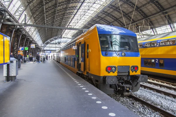 Amsterdam, Nizozemsko na 1 dubnu 2016. Železniční stanice. Regionální vlak na nástupišti. Cestující přejít na platformě. — Stock fotografie