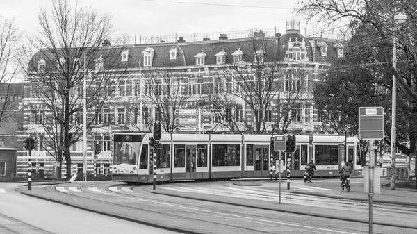 AMSTERDAM, NETHERLANDS, 27 марта 2016 года. Типичный вид на город весной утром. Трамвай едет по улице. — стоковое фото