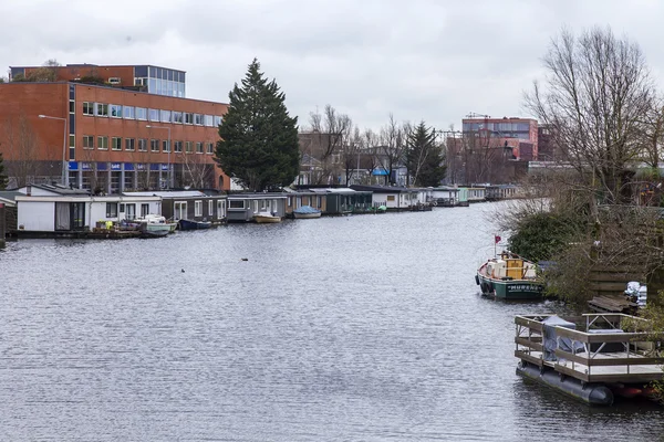 AMSTERDAM, PAESI BASSI il 27 marzo 2016. Tipica vista urbana al mattino di primavera. Il fiume Amstel. Complesso architettonico del terrapieno . — Foto Stock