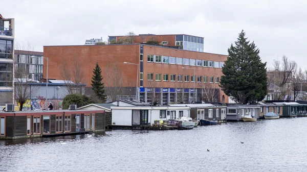 Amsterdam, Hollanda üzerinde 27 Mart 2016. Bahar sabahı tipik kent görünümünde. Amstel Nehri. Set of mimari kompleks.
