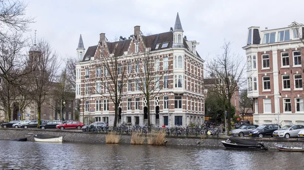 Amsterdam, Nizozemsko na 27 březen 2016. Typický městský pohled v jarní ráno. Řeka Amstel. Architektonický komplex nábřeží. — Stock fotografie