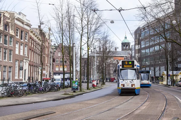 AMSTERDAM, PAESI BASSI il 27 marzo 2016. Tipica vista urbana al mattino di primavera. Il tram si muove lungo la strada — Foto Stock