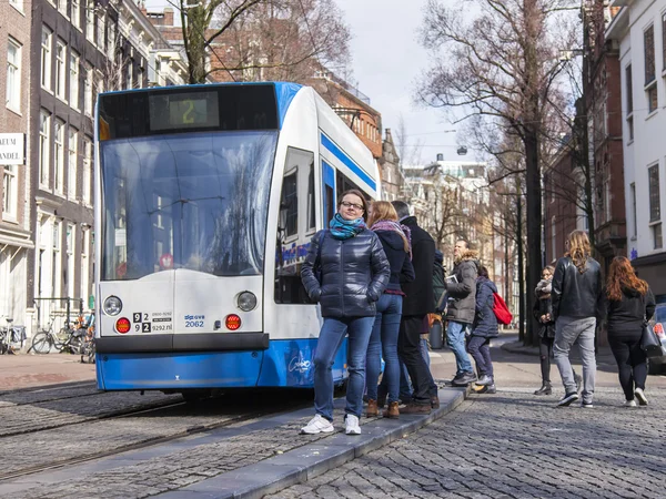 AMSTERDAM, PAÍSES BAJOS el 27 de marzo de 2016. Típica vista urbana en la mañana de primavera. El tranvía se mueve por la calle — Foto de Stock