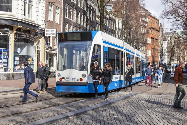 AMSTERDAM, PAESI BASSI il 27 marzo 2016. Tipica vista urbana al mattino di primavera. Il tram si muove lungo la strada — Foto Stock