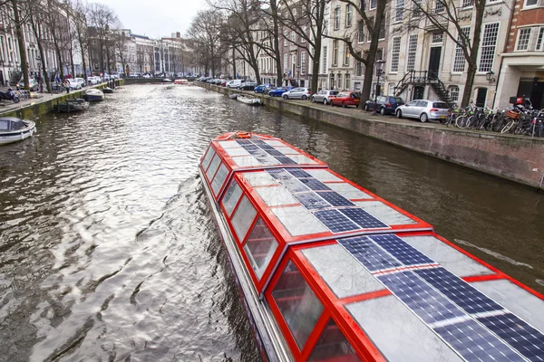 Amsterdam, Nederländerna den 27 mars, 2016. Typisk Urban utsikt under vår kvällen. Gång skeppet flyter på kanalen — Stockfoto