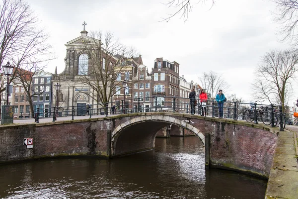 Amsterdam, Hollanda üzerinde 27 Mart 2016. Bahar akşam tipik kent görünümünde. Kanal ve Binalar bentleri tarihinde XVII-XVIII inşaatın Köprüsü — Stok fotoğraf