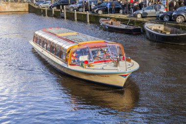 Amsterdam, Hollanda üzerinde 27 Mart 2016. Bahar akşam tipik kent görünümünde. Kanal ve Binalar bentleri tarihinde XVII-XVIII inşaatın Köprüsü
